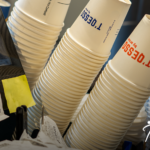 Endüstriyel matbaa makinesinde plastik üzerine serigrafi baskı aşamasından geçen yüksek çözünürlüklü şeffaf ambalaj kapları.